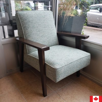 Mid century modern accent chair with dark wood arms, and upholstered seat and back in a light teal textured fabric.
