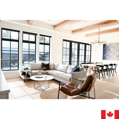 Large living room with light grey sectional sofa. Has slim boxy arms, and a silver metal leg.